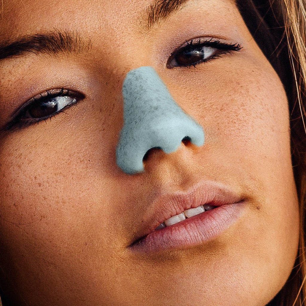  Young woman wearing blue NOZ sunscreen color on her nose